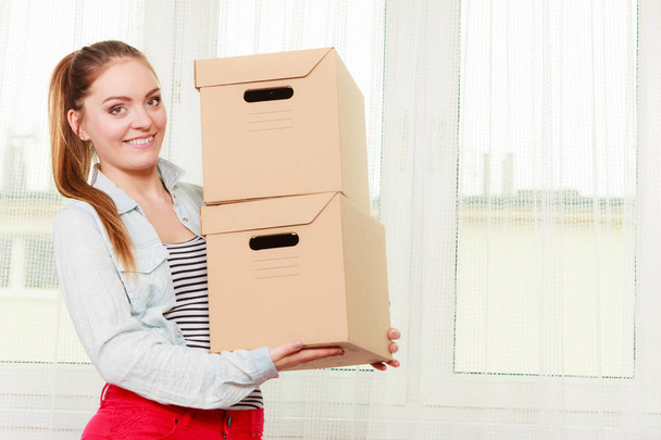 Woman moving into apartment house carrying boxes. - 写真・画像