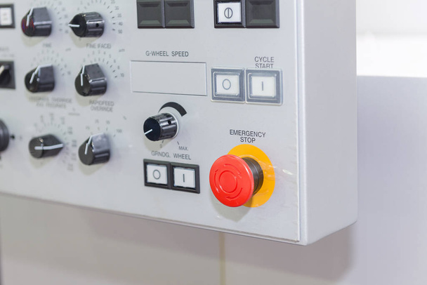 O botão de parada de emergência no painel de controle do CNC
  - Foto, Imagem