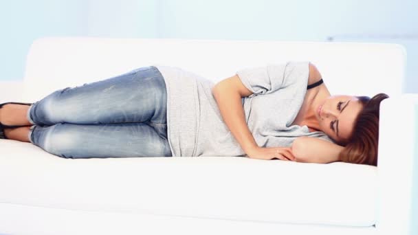 Gyönyörű fiatal nő alszik a kanapén - Felvétel, videó
