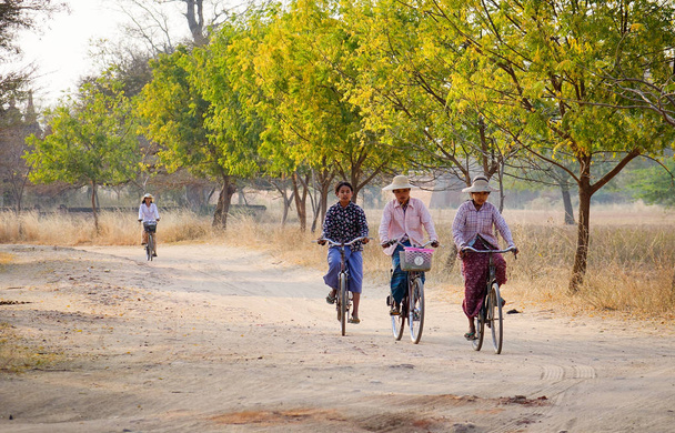 Bagan, Myanmar - Feb 19, 2016. People biking on rural road in Bagan, Myanmar. - Фото, изображение