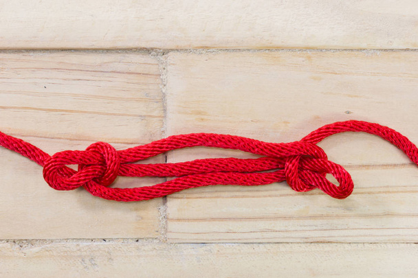 Sheepshank knot made with red rope on wooden background. - Photo, Image