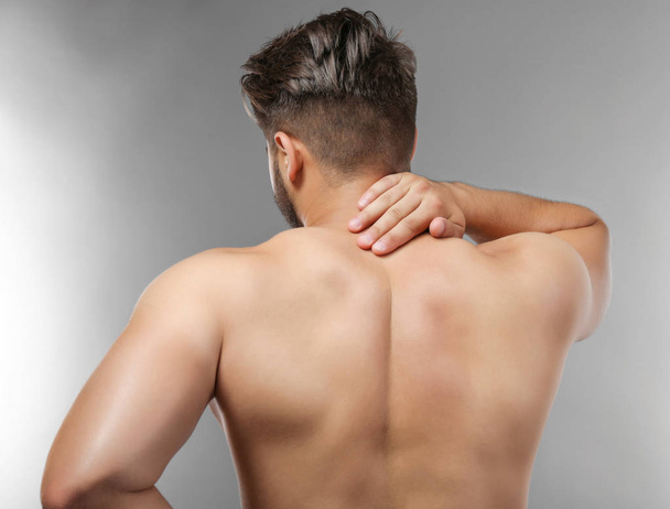 Man with neck pain on grey background - Zdjęcie, obraz