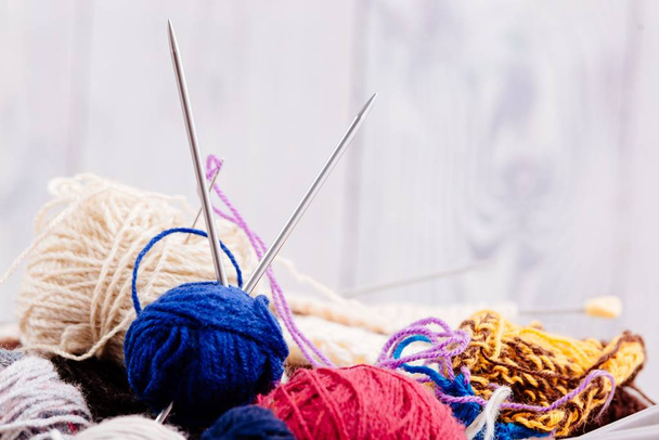 Boules et aiguilles de laine colorées dans un panier en bois
 - Photo, image