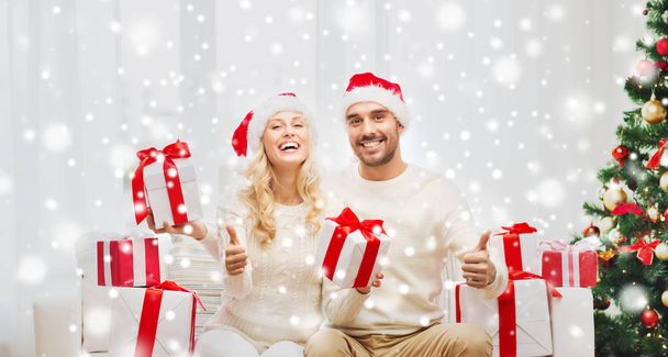 happy couple with christmas gifts and thumbs up - Фото, зображення