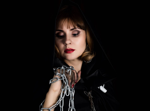 mysterious young woman holding rope and chain. on a dark background - Φωτογραφία, εικόνα