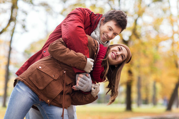 glückliches junges Paar vergnügt sich im Herbstpark - Foto, Bild