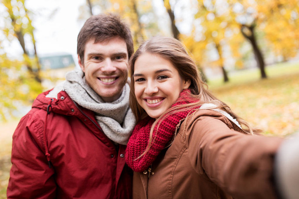 happy young couple taking selfie in autumn park - Foto, imagen