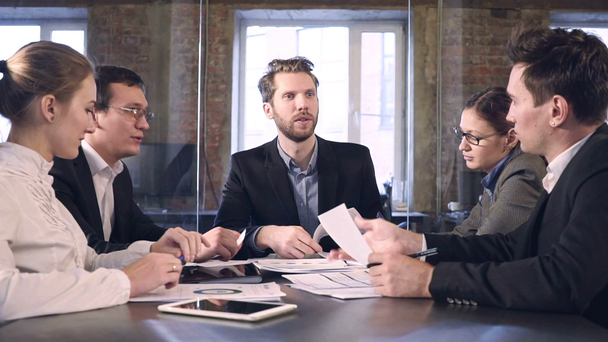 деловые партнеры обсуждают документы и идеи на встрече - Кадры, видео