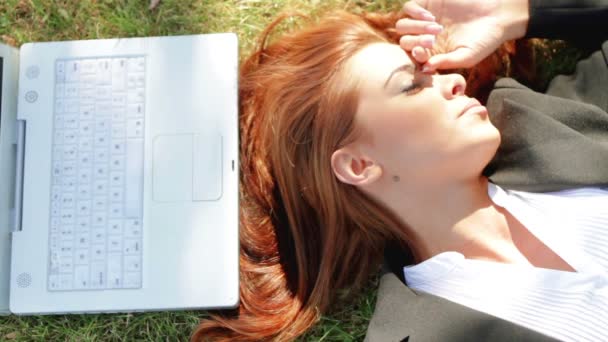 Mujer de negocios hermosa relajarse en la hierba con el ordenador portátil
 - Metraje, vídeo