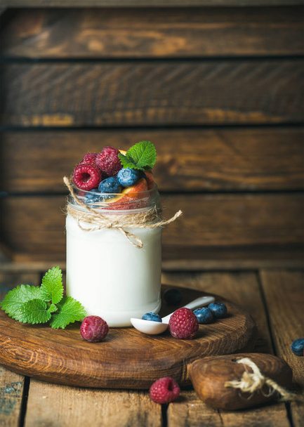 White yogurt with fresh berries, peach and mint leaves - Foto, immagini