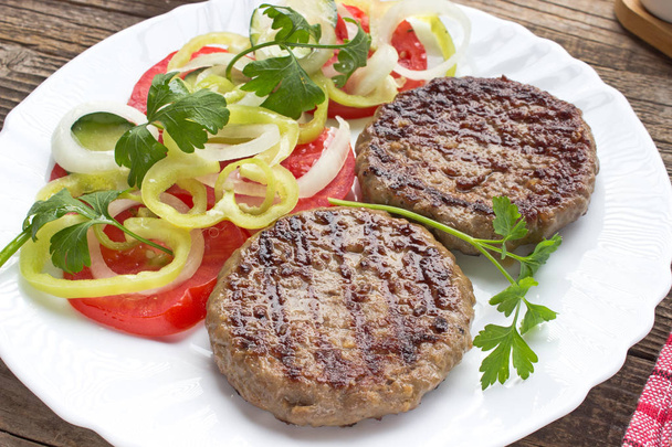 Grilled hamburger in plate with vegetable salad - Photo, Image