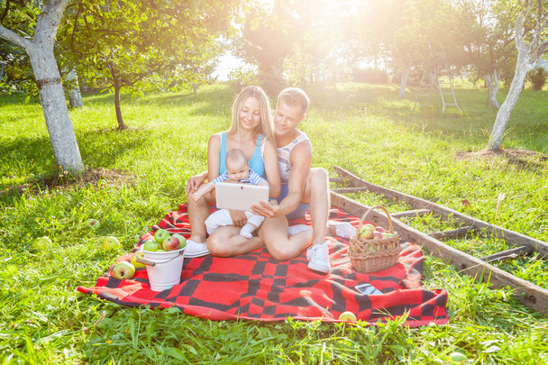 Happy family enjoying a picnic outdoors - Foto, afbeelding