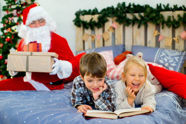 Santa Claus quietly came to the children who are reading - Zdjęcie, obraz