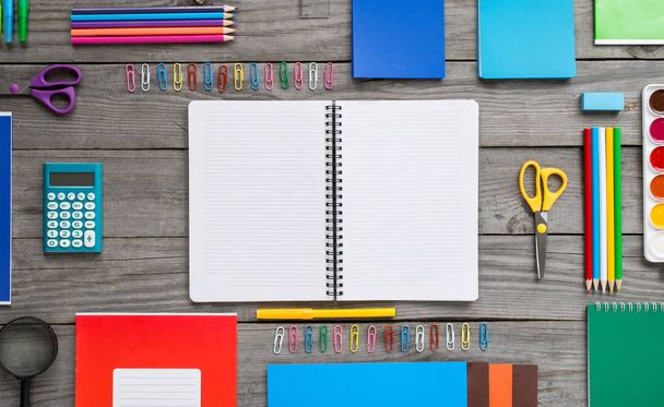 Open notebook with school supplies on the wooden table - Foto, Imagen