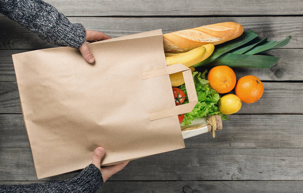 Man's hands holding paper bag of groceries - Photo, Image
