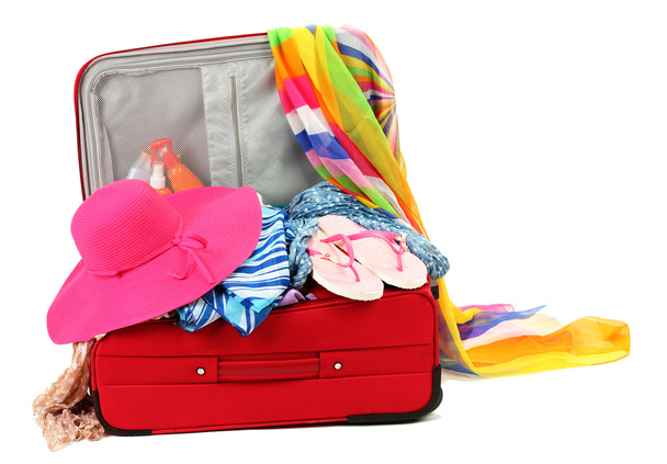 Suitcase with summer clothes, a hat and suntan isolated on white - Foto, Imagem