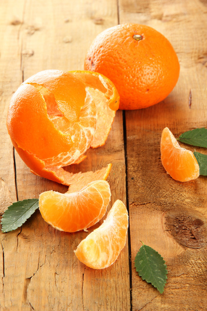 Ripe tasty tangerines on wooden background - 写真・画像
