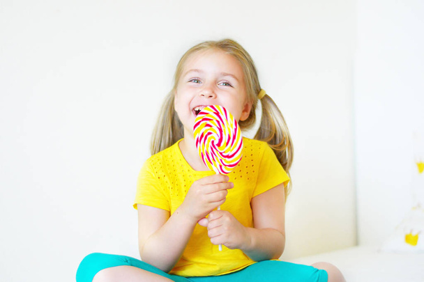 Engraçado menina comendo grande açúcar pirulito
 - Foto, Imagem