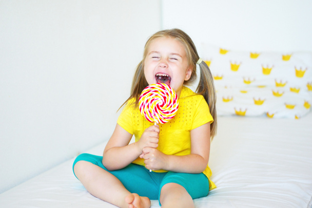 Divertido niña comiendo gran piruleta de azúcar
 - Foto, imagen