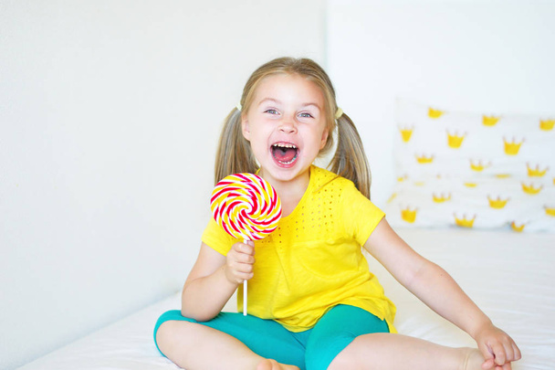 Divertido niña comiendo gran piruleta de azúcar
 - Foto, imagen