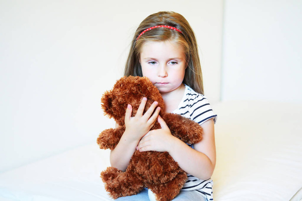 Petite fille déprimée embrassant ours en peluche
 - Photo, image