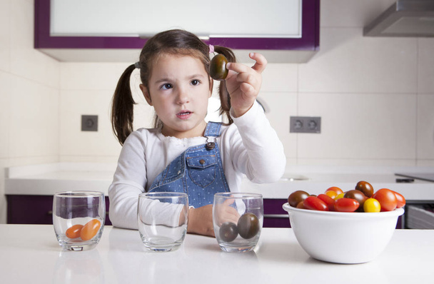 Mała dziewczynka sortowanie według kolorów pomidorkami - Zdjęcie, obraz