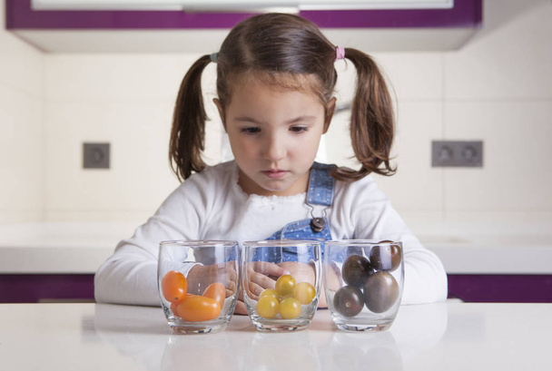 Bambina osservando pomodorini varietà colori
 - Foto, immagini