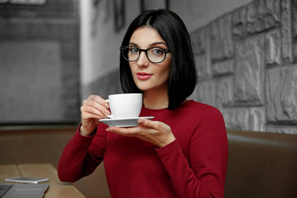 Beautiful young woman drinking coffee at cafe - Valokuva, kuva