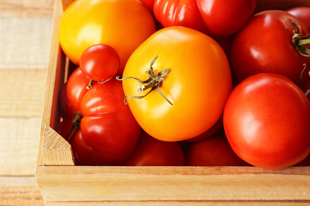 Different tomatoes in wooden box, close up - Φωτογραφία, εικόνα