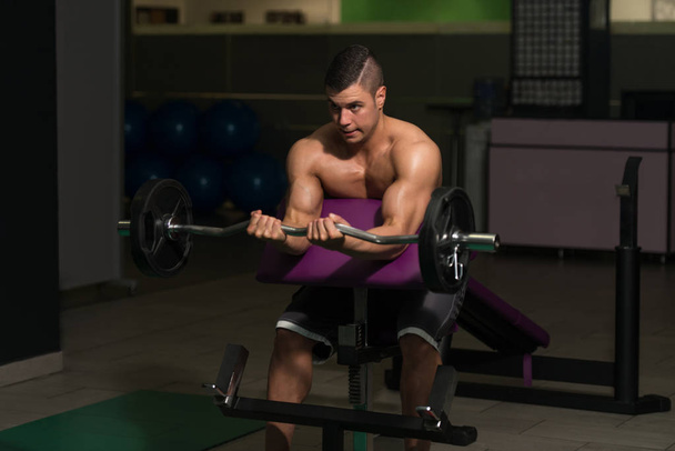 Man In The Gym Exercising Biceps With Barbell - Fotoğraf, Görsel