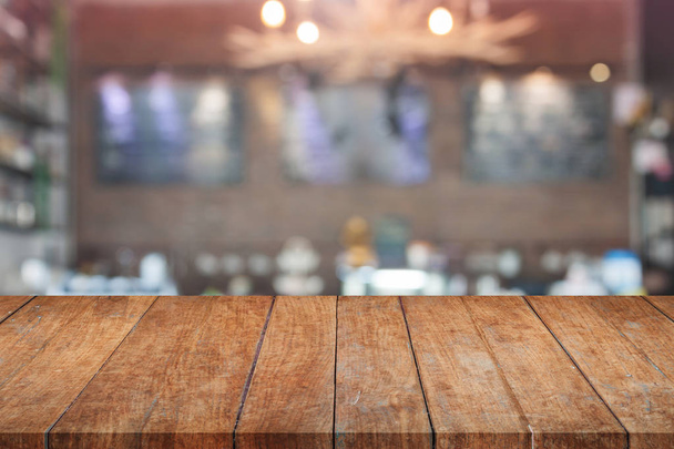 Brown wooden table top with blurred cafe - Foto, Bild