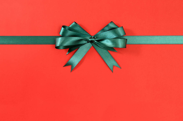 Verde regalo cinta arco recto horizontal papel rojo fondo
 - Foto, Imagen