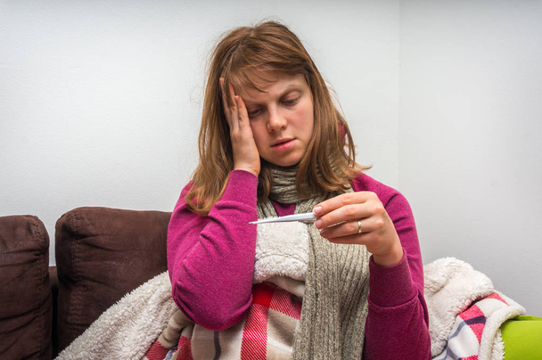 Jeune femme malade avec thermomètre ayant la grippe et des maux de tête
 - Photo, image