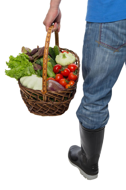 farmer in boots carrying a basket of vegetables - Foto, Imagen