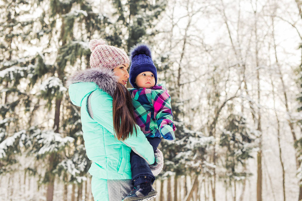 happy family mother and baby girl daughter playing and laughing in winter outdoors in the snow. - 写真・画像