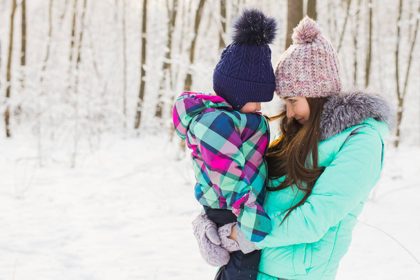 Щаслива мати і дитина в зимовому парку. сім'я на відкритому повітрі. весела мама зі своєю дитиною
 - Фото, зображення