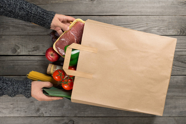Man looks bag full of different healthy food - Zdjęcie, obraz