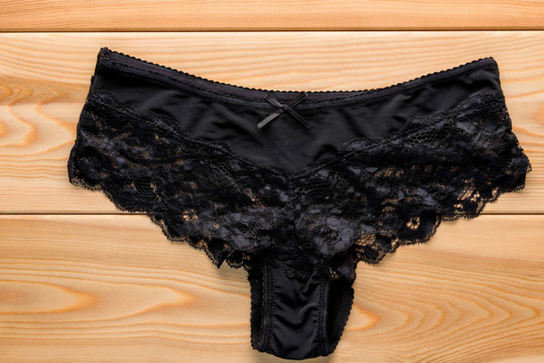 feminine satin panties with lace in black on the wooden floor cl - Photo, Image