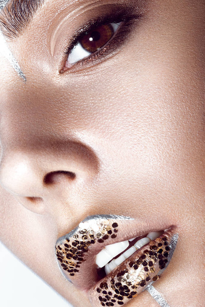 Beautiful fashionable girl with creative glitter makeup and sparkles on lips. Close up beauty face. - Foto, afbeelding