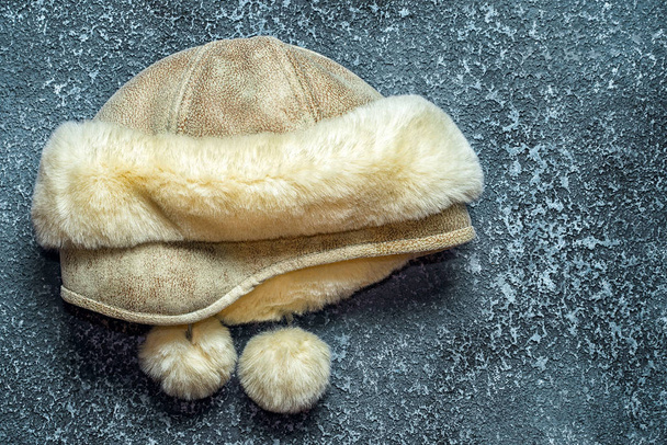 女性の冬帽子革と毛皮暗いセメントの背景に - 写真・画像