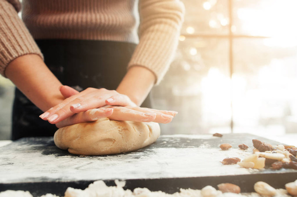 Female hands kneading dough, sunset background - Photo, Image