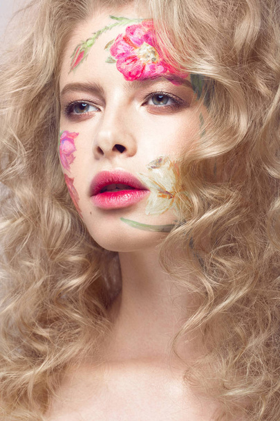 Beautiful blond girl with curls and a floral pattern on the face. Beauty flowers. - Фото, изображение