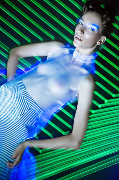 Fashion model beautiful girl in fashionable clothes in ultraviolet light, showing different poses. Beauty body and face. - Foto, imagen