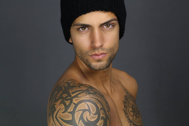 szép tetovált férfi pózol  - Fotó, kép