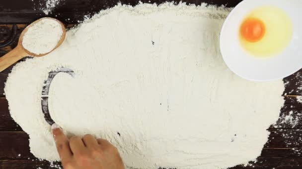 Top view Young man writes a word gluten on white flour at wooden desk from above. - Footage, Video