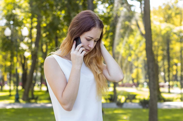 woman talking on the phone in the park - Φωτογραφία, εικόνα