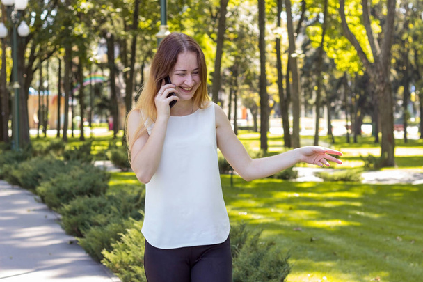 woman talking on the phone in the park - Фото, изображение