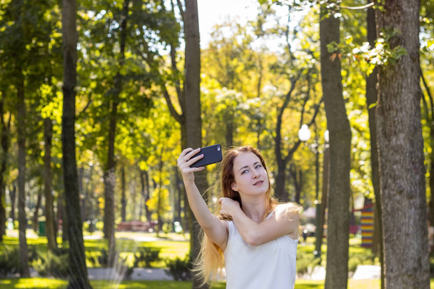 woman making selfie in the park - Photo, Image