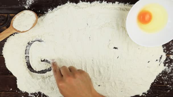 Top view Young man writes a word gluten strikethrough on white flour at wooden desk from above. - Footage, Video