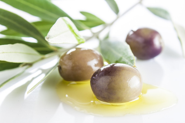 Оливки и масло с листьями, неглубокая глубина поля
 - Фото, изображение
